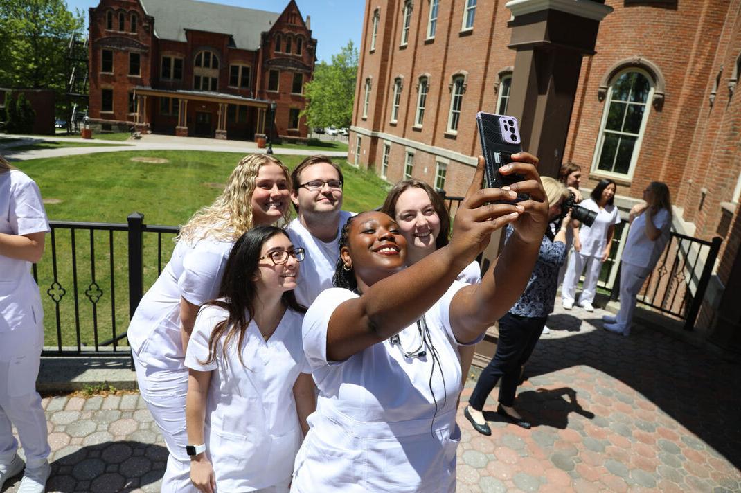 A group of nursing graduates pose for a selfie before their pinning ceremony
