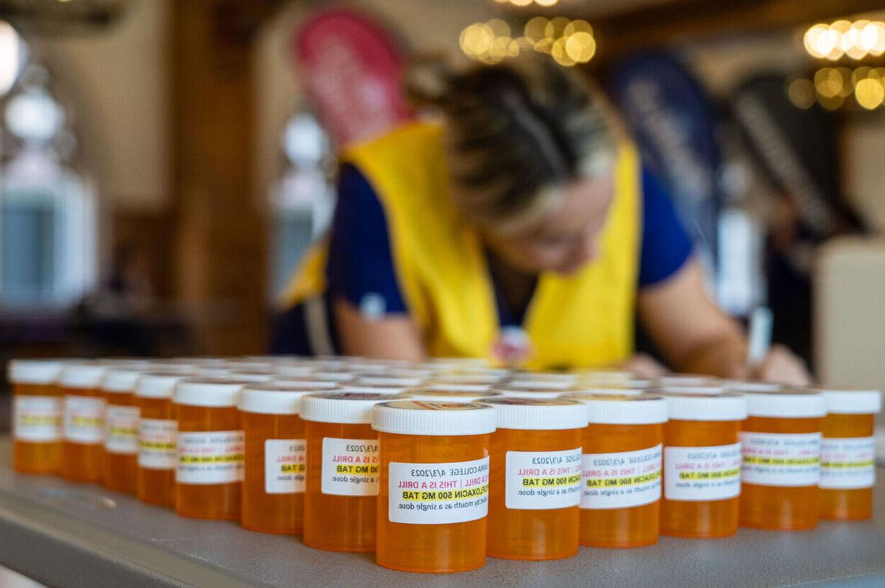 在一次紧急训练中，一名护生在各种药瓶旁填写表格 