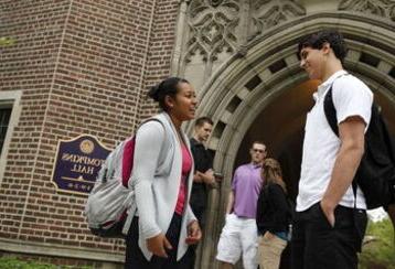 在汤普金斯大厅的入口附近，一男一女学生有说有笑，其他学生在后面说话
